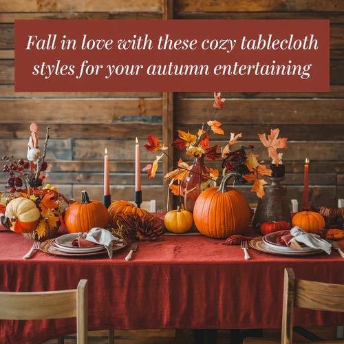 A photo of a cozy table setting with a red tablecloth and autumn-themed decorations. There are pumpkins, leaves, and candles on the table. The background is a rustic wooden wall