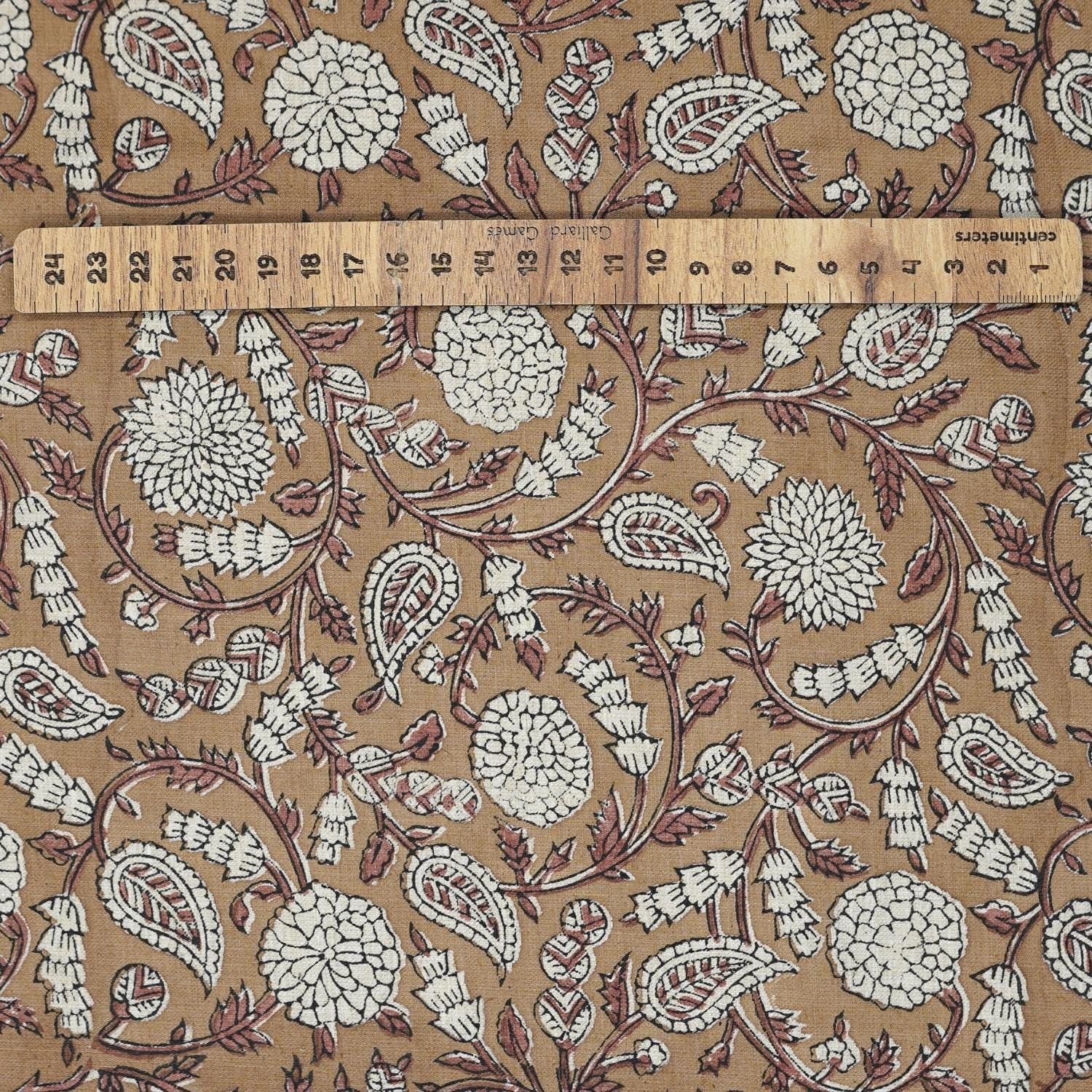 Hand-stamped Indian art on brown natural linen blend fabric, displayed on a farmhouse table and matching curtain in neutral earthy tones.