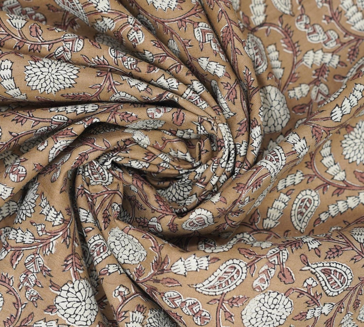 Indian hand made art shown on a brown block print fabric, ideal for festive tablecloths, drapery, and rustic style farmhouse cushions.