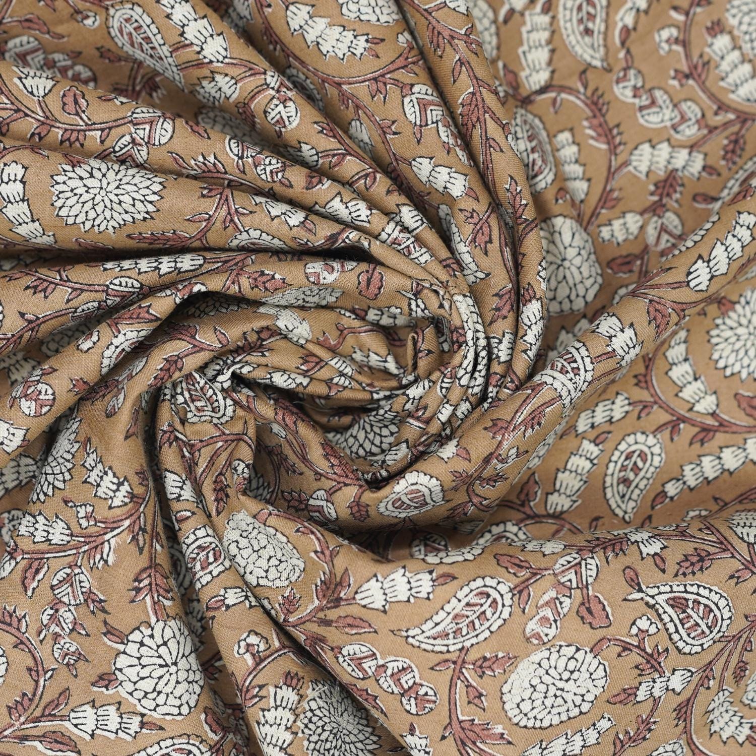 Indian hand made art shown on a brown block print fabric, ideal for festive tablecloths, drapery, and rustic style farmhouse cushions.