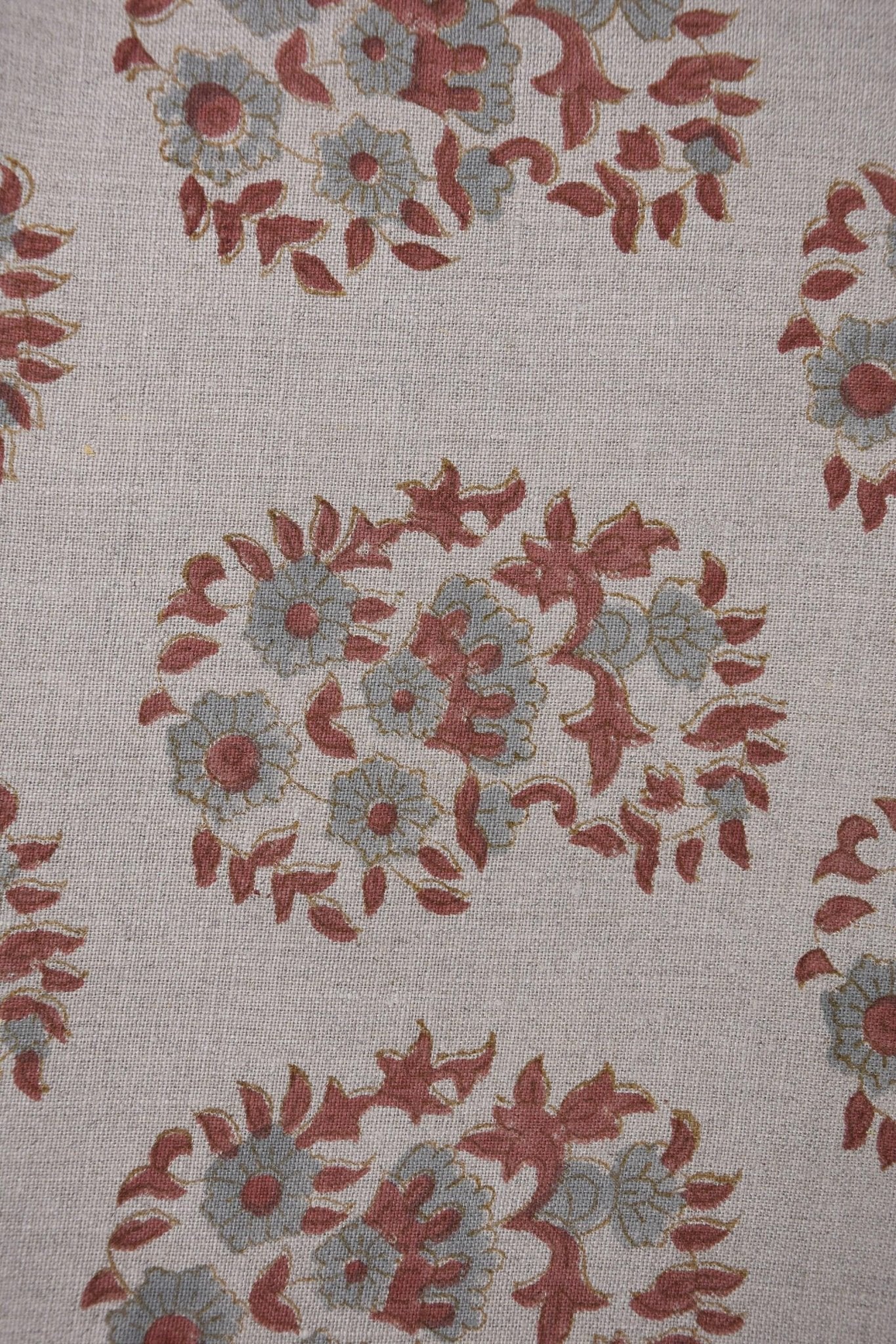 Detailed view of beige floral fabric with red and blue flowers