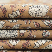 Gopi floral print in brown color showcased on natural linen blend, styled in tablecloths and cushion sets for festive decor themes.