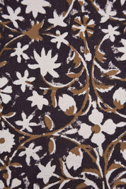 Close-up of a floral patterned fabric with white and brown flowers on a dark background