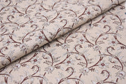 Floral patterned fabric with brown and white design on beige background