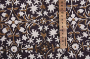 Floral patterned fabric with a ruler for scale on a dark background