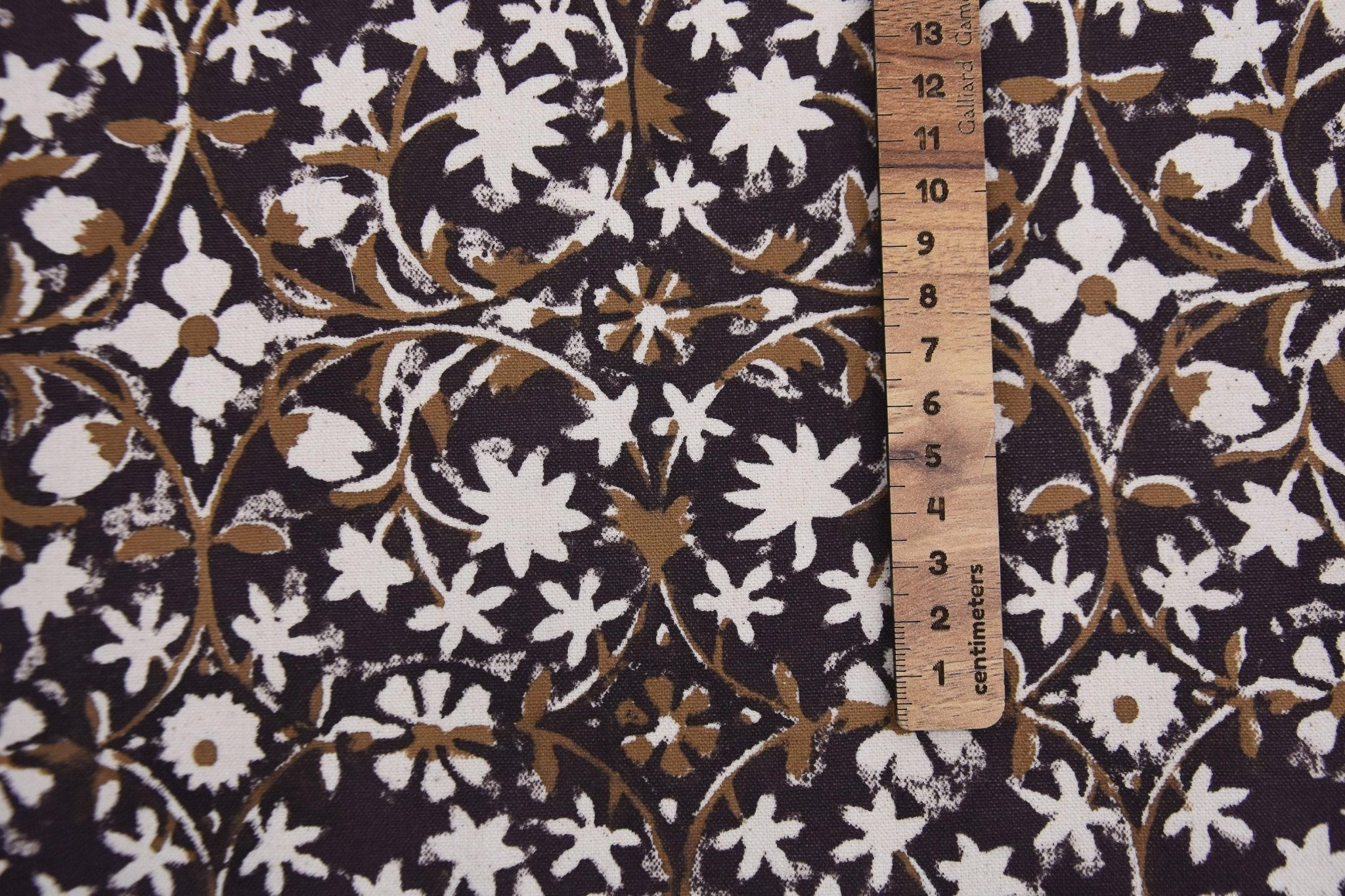Floral patterned fabric with a ruler for scale on a dark background