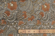 Floral paisley patterned fabric with a wooden ruler for scale.