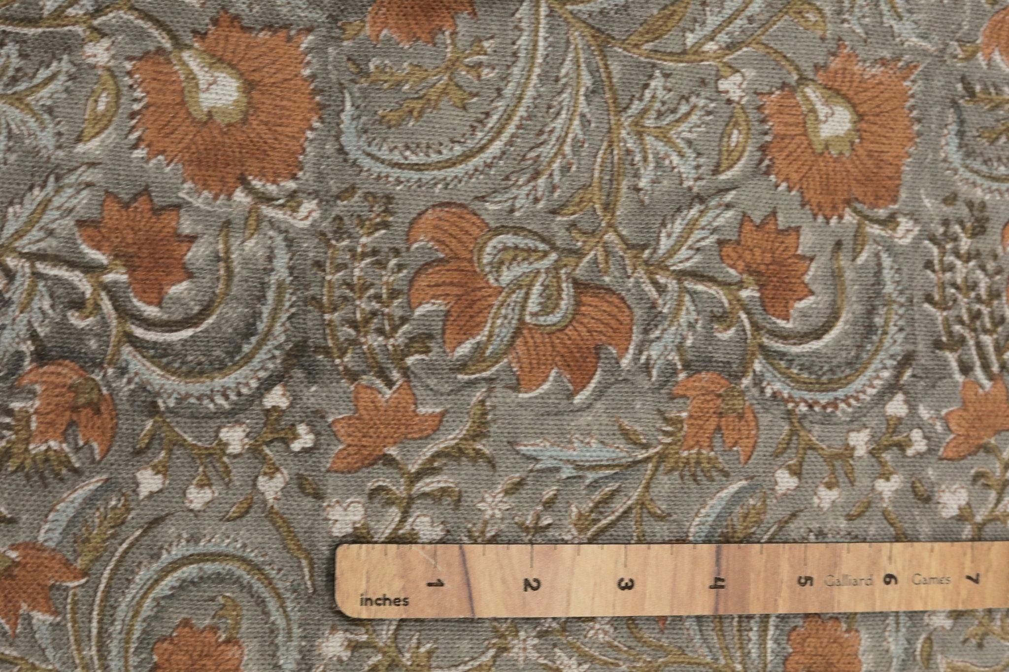 Floral paisley patterned fabric with a wooden ruler for scale.
