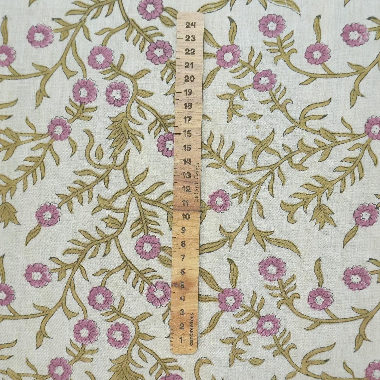 Floral fabric pattern with a ruler for scale on a white background