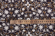 Floral patterned fabric with a ruler for scale on a dark background