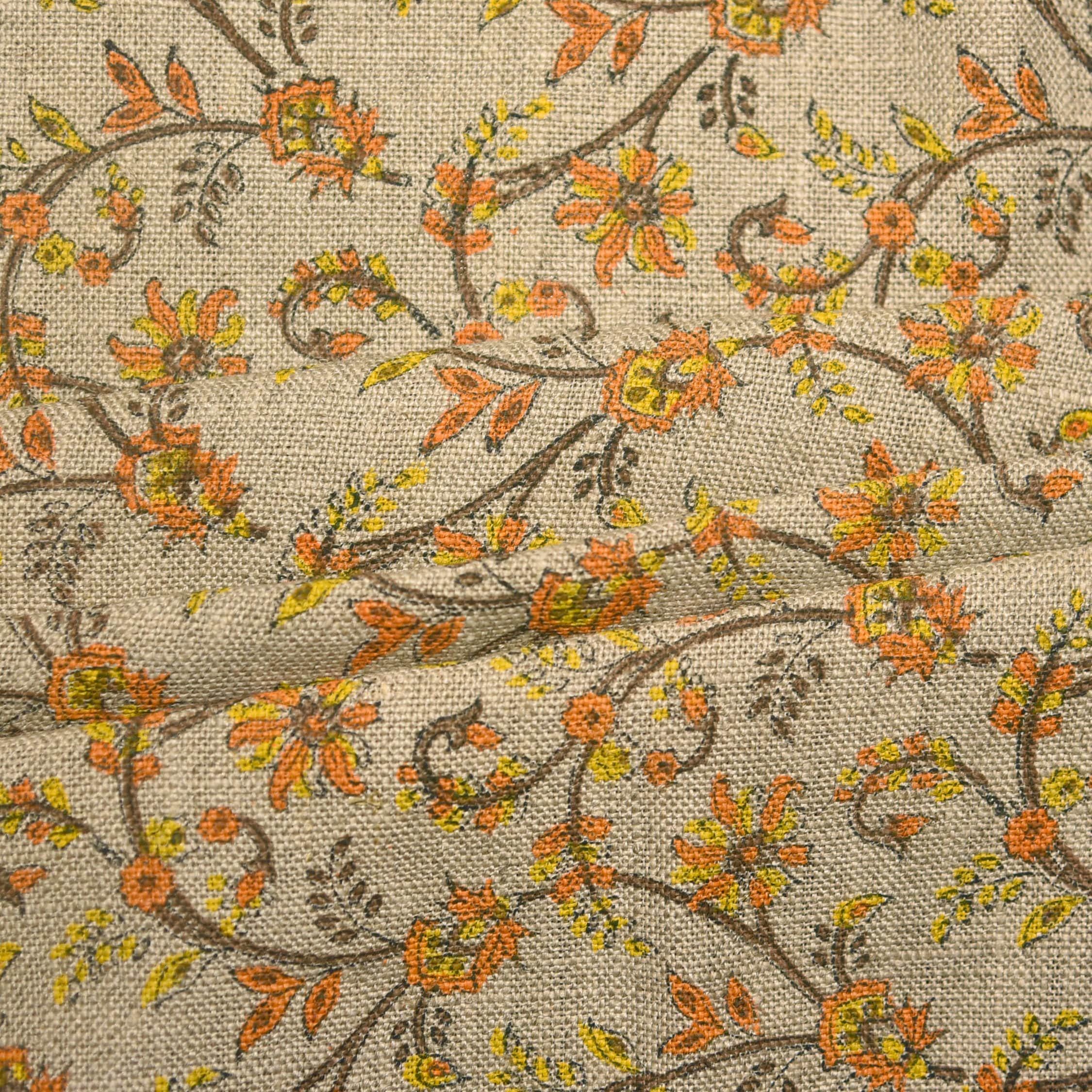 Floral patterned fabric with orange and yellow flowers on a beige background