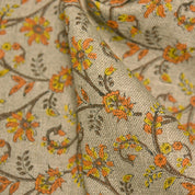 Close-up of floral fabric with orange, yellow, and brown colors on a beige background