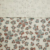 Two fabric swatches, one plain and one with a floral pattern, on a textured beige background.