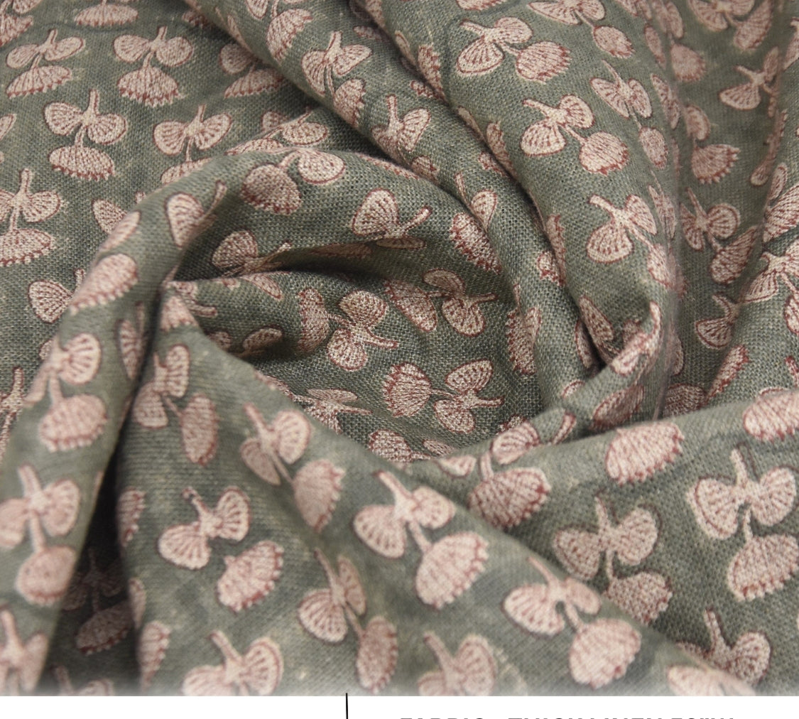 Close-up of green fabric with pink floral pattern, labeled 'Damaru' and 'Thick Linen'.