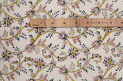 Floral patterned fabric with a wooden ruler for scale on a beige background