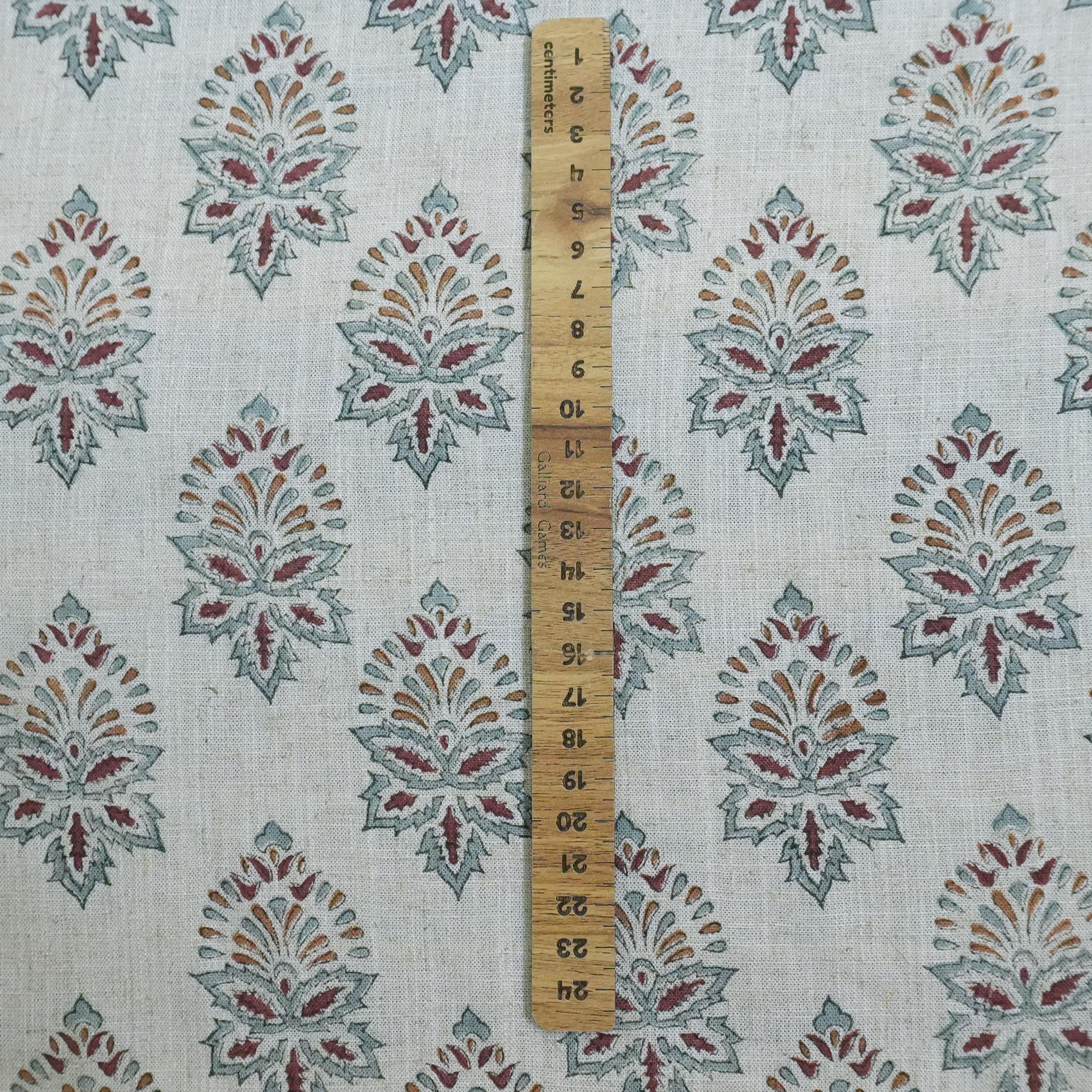 Fabric with a pattern of geometric shapes and a wooden ruler for scale.