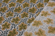 Close-up of fabric with leaf pattern in green and brown on a textured background
