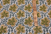 Fabric with leaf pattern and a ruler for scale and fabric name is pushp smhita
