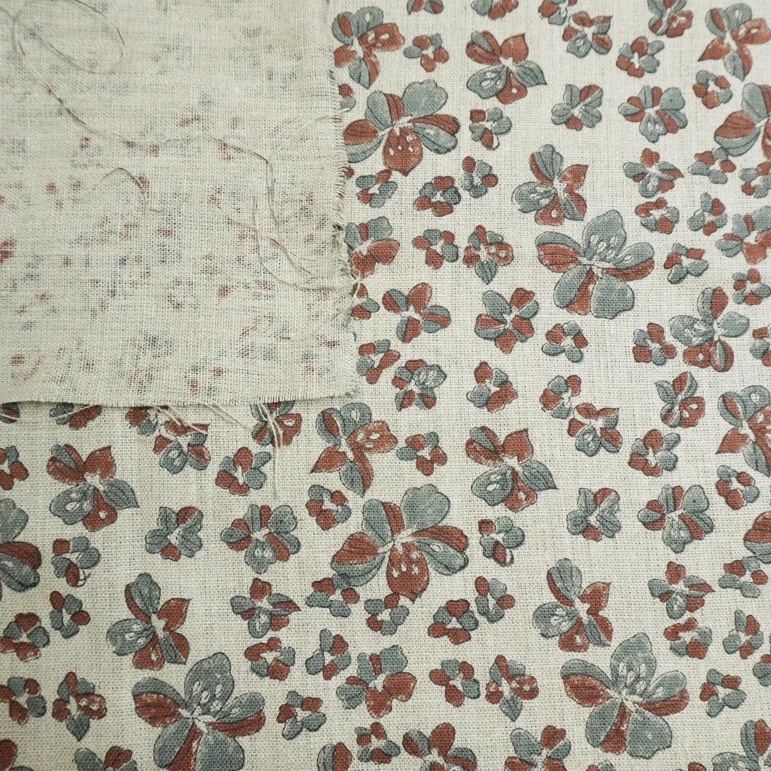 Floral patterned fabric with red and green flowers on a beige background